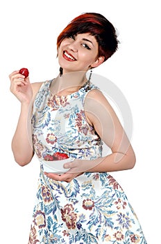 Young smiling girl eating strawberries.