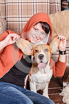 Young smiling girl with happy and silly beagle dog who shows the tongue