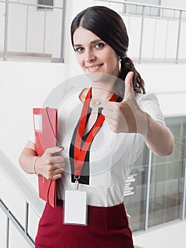 Young Smiling Girl Made Successful Work Shows Gesture Big Thumb Up. Beautiful Smiling Businesswoman Standing Against White Offices