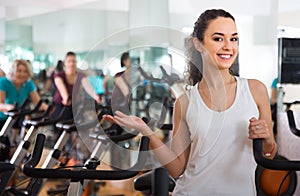 Young smiling girl practicing on exercise bikes