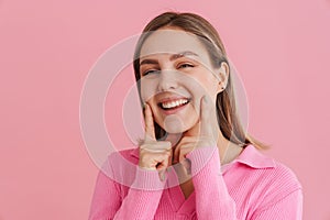 Young smiling girl touching her forefingers on her cheeks photo