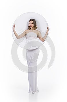 A young,smiling girl in white conceptual dress .