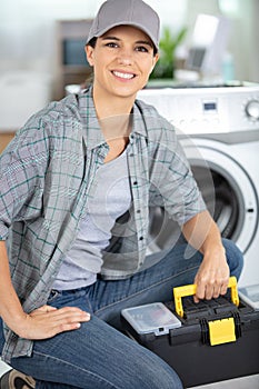 young smiling handywoman holding toolbox