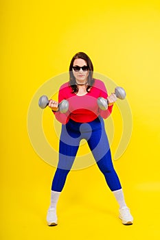 Young smiling happy chubby overweight plus size big fat fit woman warm up training hold dumbbells