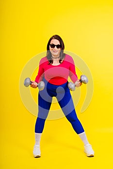 Young smiling happy chubby overweight plus size big fat fit woman warm up training hold dumbbells