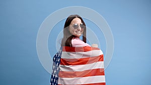 Young smiling happy woman wears casual clothes holding American flag and looking to the camera
