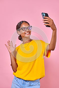 Young smiling Indian woman teenager says hello and shoots vlog on phone camera