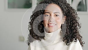 Young smiling latin woman posing at home looking at camera. Portrait