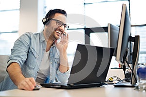 Young smiling male call center operator doing his job with a headset.Portrait of call center worker at office.