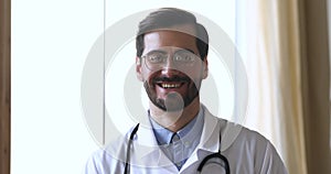 Young smiling male general practitioner in eyewear looking at camera.