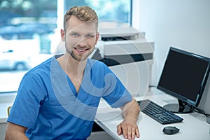 Young smiling male medic in the office