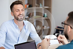 Young smiling man attending job interview with skilled hr manager.