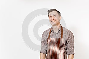 Young smiling man chef or waiter wearing striped brown apron, shirt posing isolated on white background. Male
