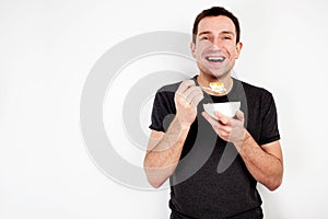 Young smiling man eating cereal