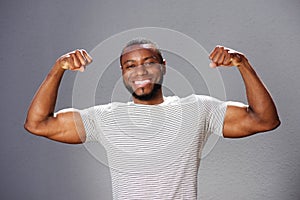 Young smiling man flexing arm muscles