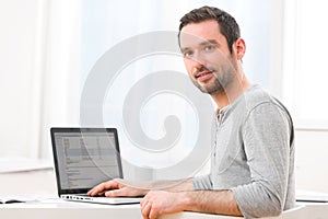 Young smiling man in front of a computer