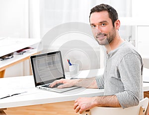 Young smiling man in front of a computer