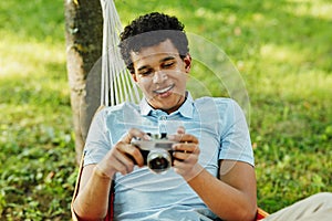 Young smiling man holding a film camera
