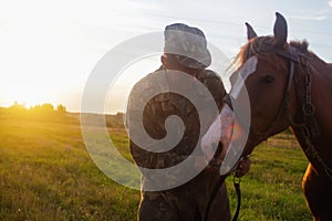 Young smiling man and horse. Loving tender moment between man and horse. Horse nose caress. Nature meadow background