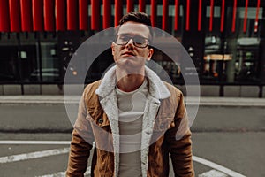 Young smiling man, model of fashion Guy with beard and modern hairstyle in urban background.