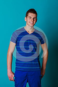 Young smiling man portrait on blue