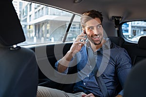 Young man talking over phone in taxi