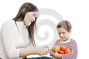 Young smiling mom with a son are vegetarians. The boy holds tangerines in his hands. Isolated over white background