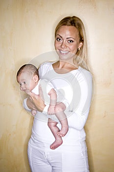Young smiling mother holding newborn baby boy