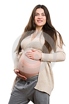 Young smiling pregnant woman grabbing her tummy