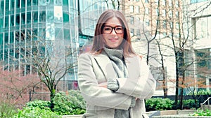 Young smiling professional business woman standing on big street, portrait.