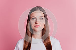 Young smiling readhead girl look at camera on pink background