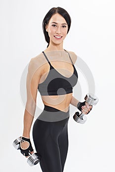 Young smiling sportswoman in black sportswear with steel dumbbells