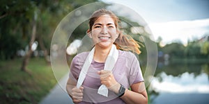 Young smiling sporty woman running in park in the morning. Fitness girl jogging in park