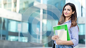 Young smiling student holding books, study, education, knowledge, goal concept