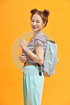 Young smiling student woman. Over yellow background