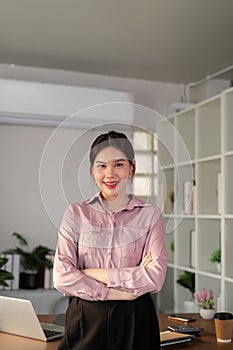 Young smiling successful employee business woman work stand at workplace desk at home office . Achievement career