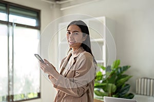 Young smiling successful employee business woman work use hold tablet stand at workplace desk at home office