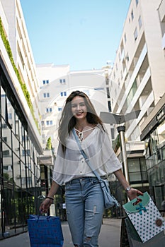 Young smiling teenager girl walking on street.