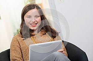 Young smiling teenager using a tablet computer