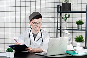 Young and smiling therapist in uniform filling up documents