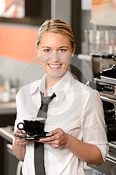 Young smiling waitress with cup of coffee