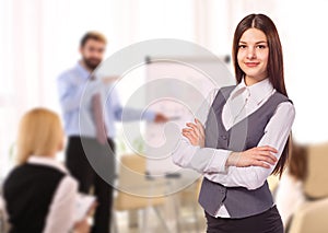 Young smiling woman with arm folded in office