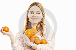 Young smiling woman with an armful of oranges photo