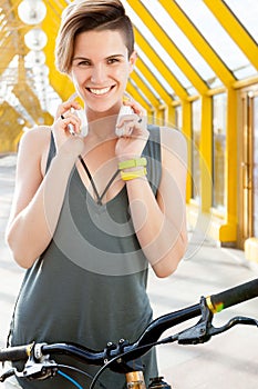 Young smiling woman with bicycle in pedestrian crossing