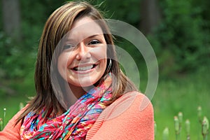 Young smiling woman in colorful sweater and scarf