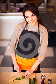 Young smiling woman cooking healthy salad