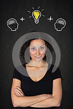 Young smiling woman with crossed arms, heads with brains and lightbulb-idea