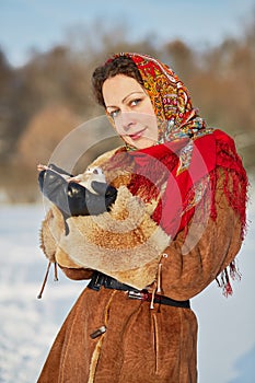 Young smiling woman dressed in sheepskin fur coat