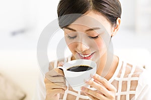 Young smiling woman drinking coffee in the morning