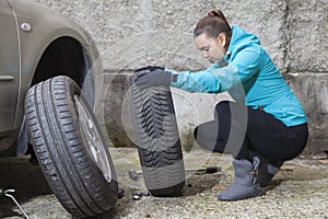 Young smiling woman driver replacing tires